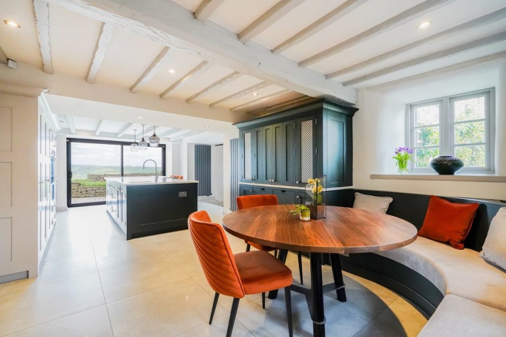 Kitchen with kitchen island opening up to countryside views through a large window