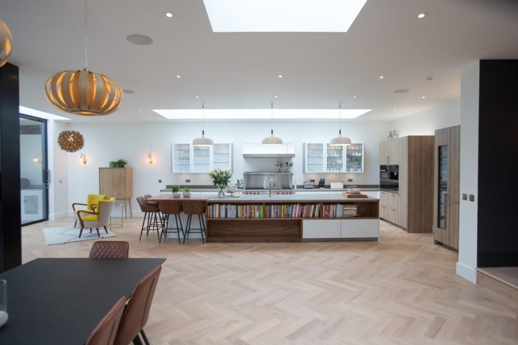 Wide view of a modern, light kitchen with a kitchen island
